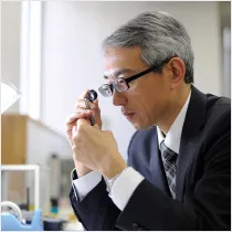 Ginza Diamond Shiraishi diamond buyer examining a diamond through a loupe